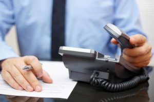 lawyer checking scheduled calls with an office telephone