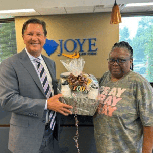 Attorney Kenny Harrell accepting a gift from Ms. Taylor at Joye Law Firm