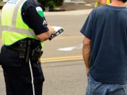 a police officer talking to a man while writing a report