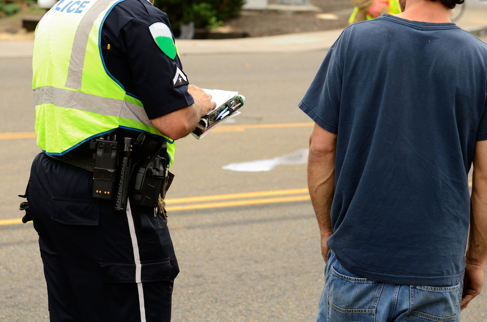 a police officer talking to a man while writing a report