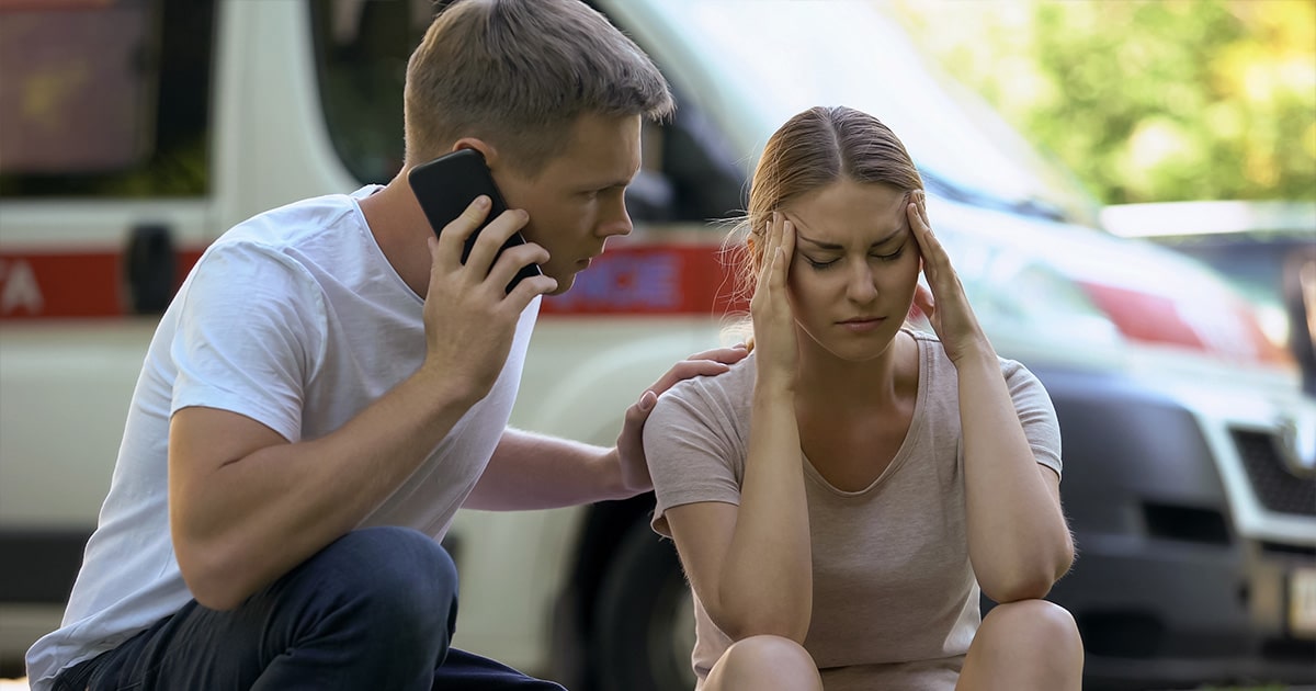 man on the phone with the police while girl is sitting on the curb