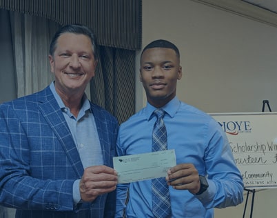 Ken Harrell awarding a check for the scholarship program to a student