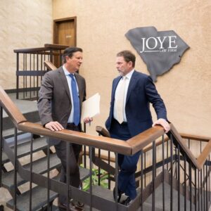 Ken Harrell and Mark Joye talking on the stairs at Joye Law Firm.
