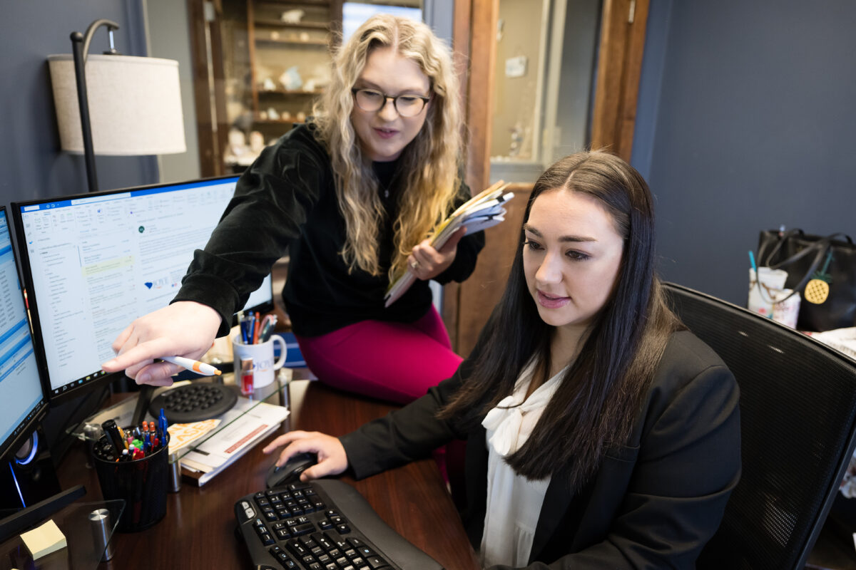 Two Case Managers discussing a case on the computer