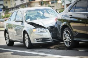 A car crash on the street with visibly damaged vehicles. 