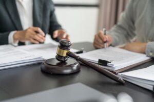 A lawyer presents a signed contract to a client, accompanied by a gavel and legal documents, symbolizing justice and a professional legal partnership. 