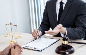 A male lawyer or judge advising clients on judicial justice and prosecution, surrounded by scales of justice, a judge's gavel, and legal documents, illustrating the concept of legal services. 